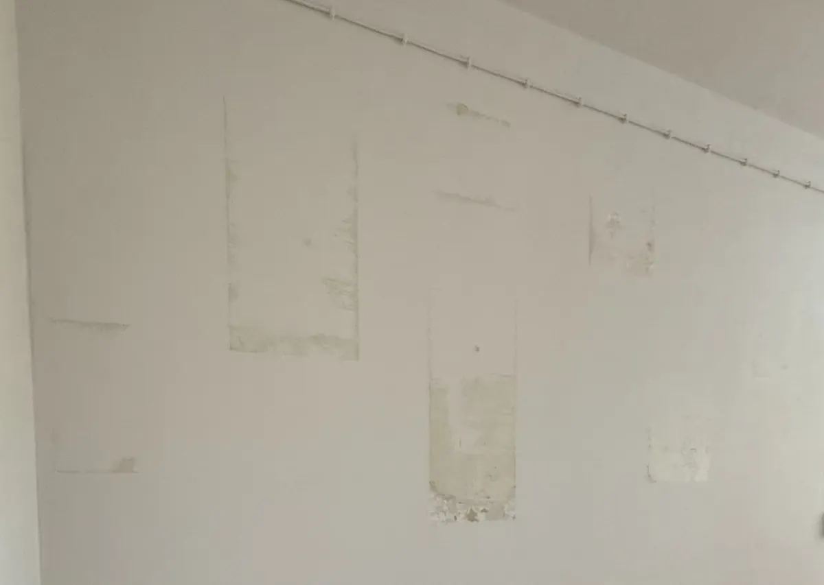 Flecken und Spuren früherer Befestigungen an der Wand