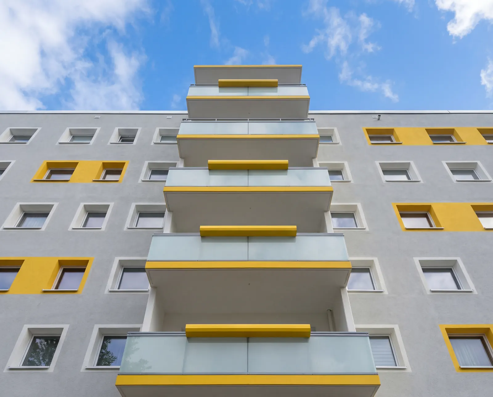 Fertig beschichtete Betonbalkone einer Wohnanlage in Grau und Gelb